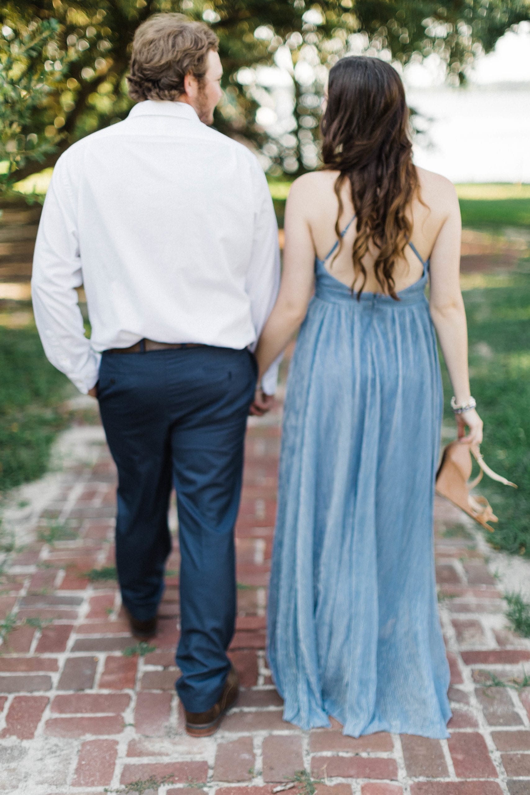 engaged couple walk down brick walkway at Biloxi's Old Brick House