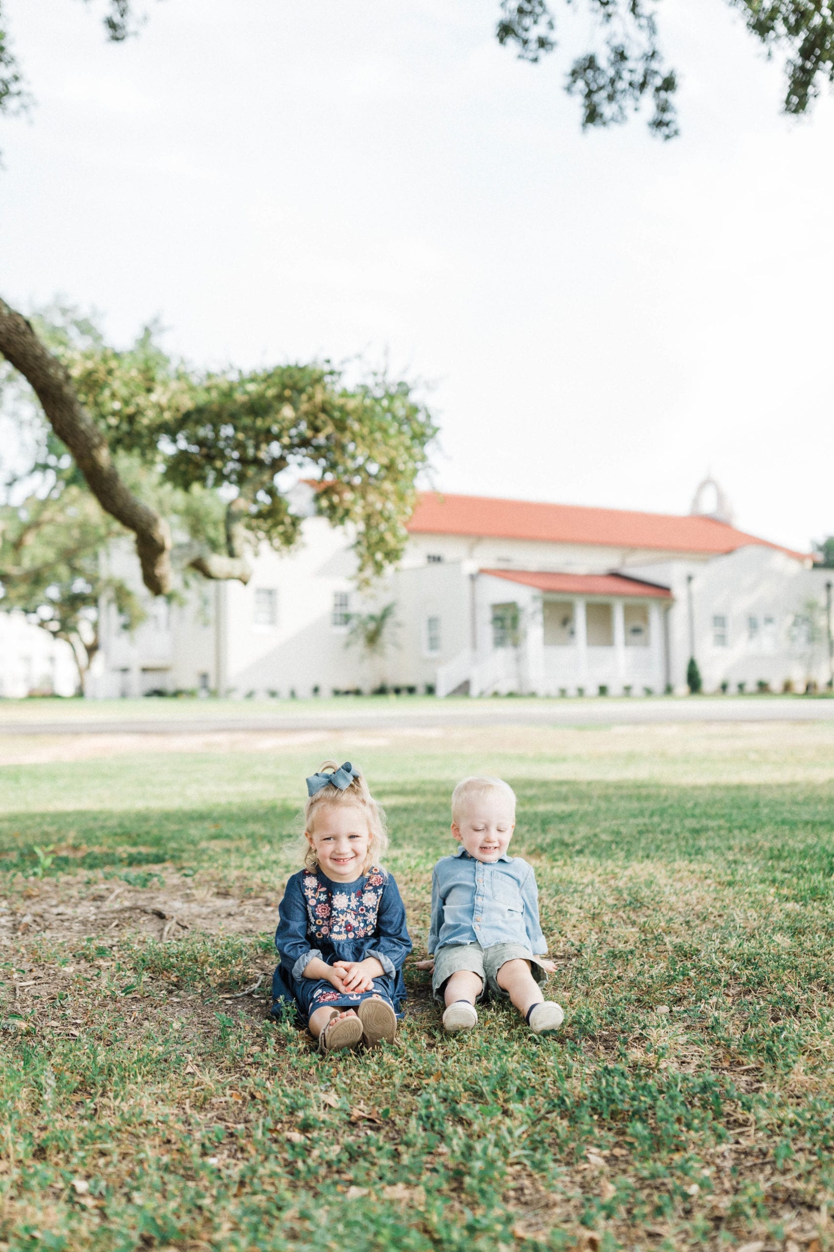 siblings sitting on grass in gulfport ms