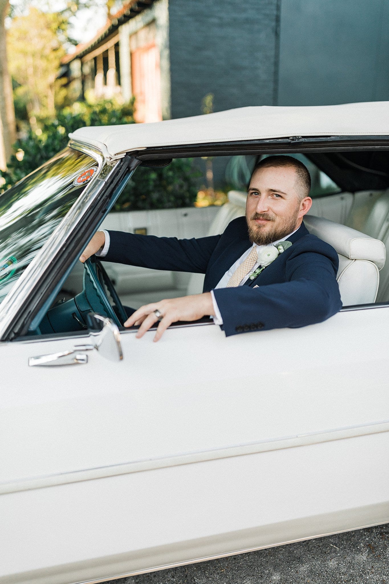 groom sitting in antique Chevrolet Caprice at the Jackson Pearl