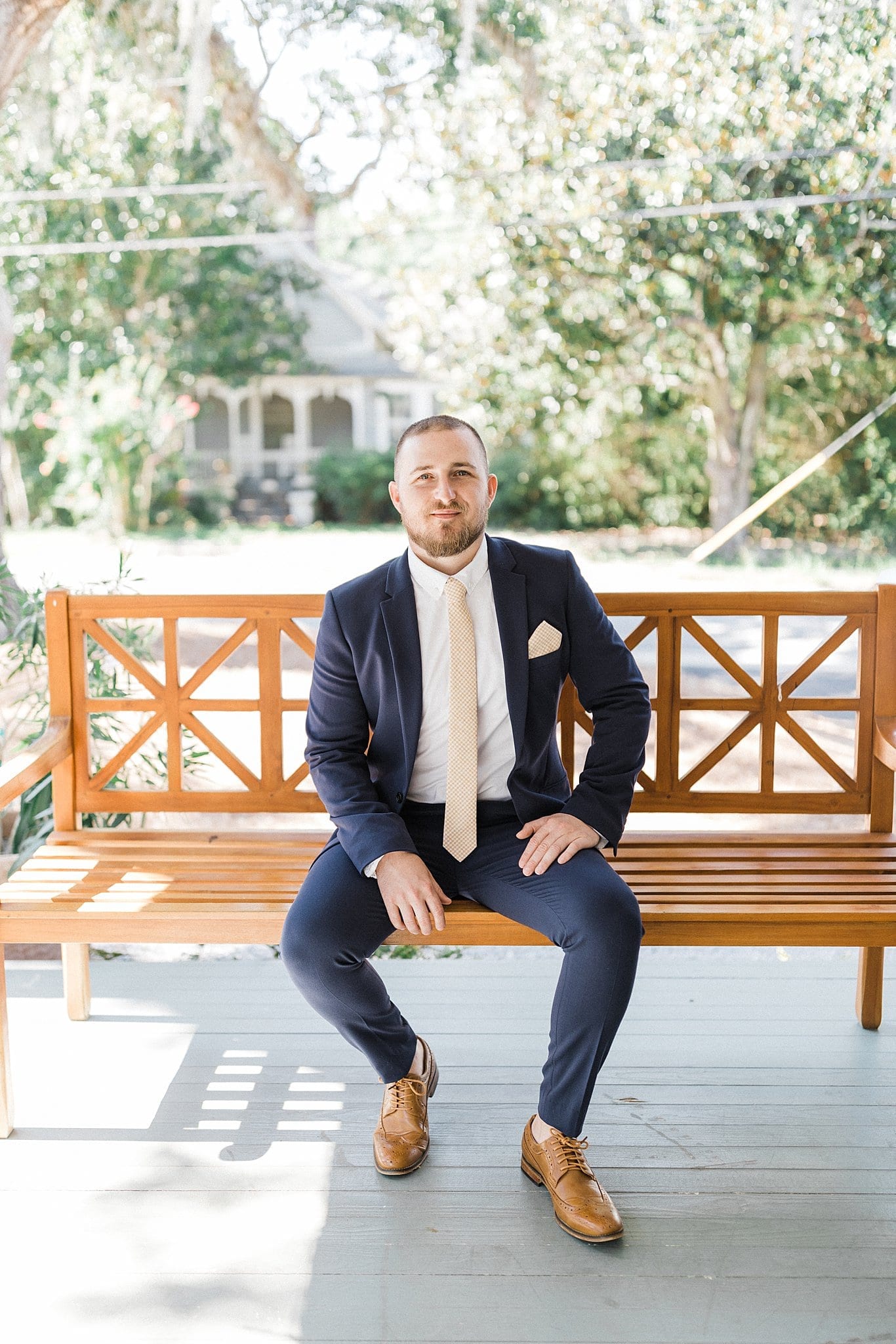 Groom sitting on front porch of The Roost
