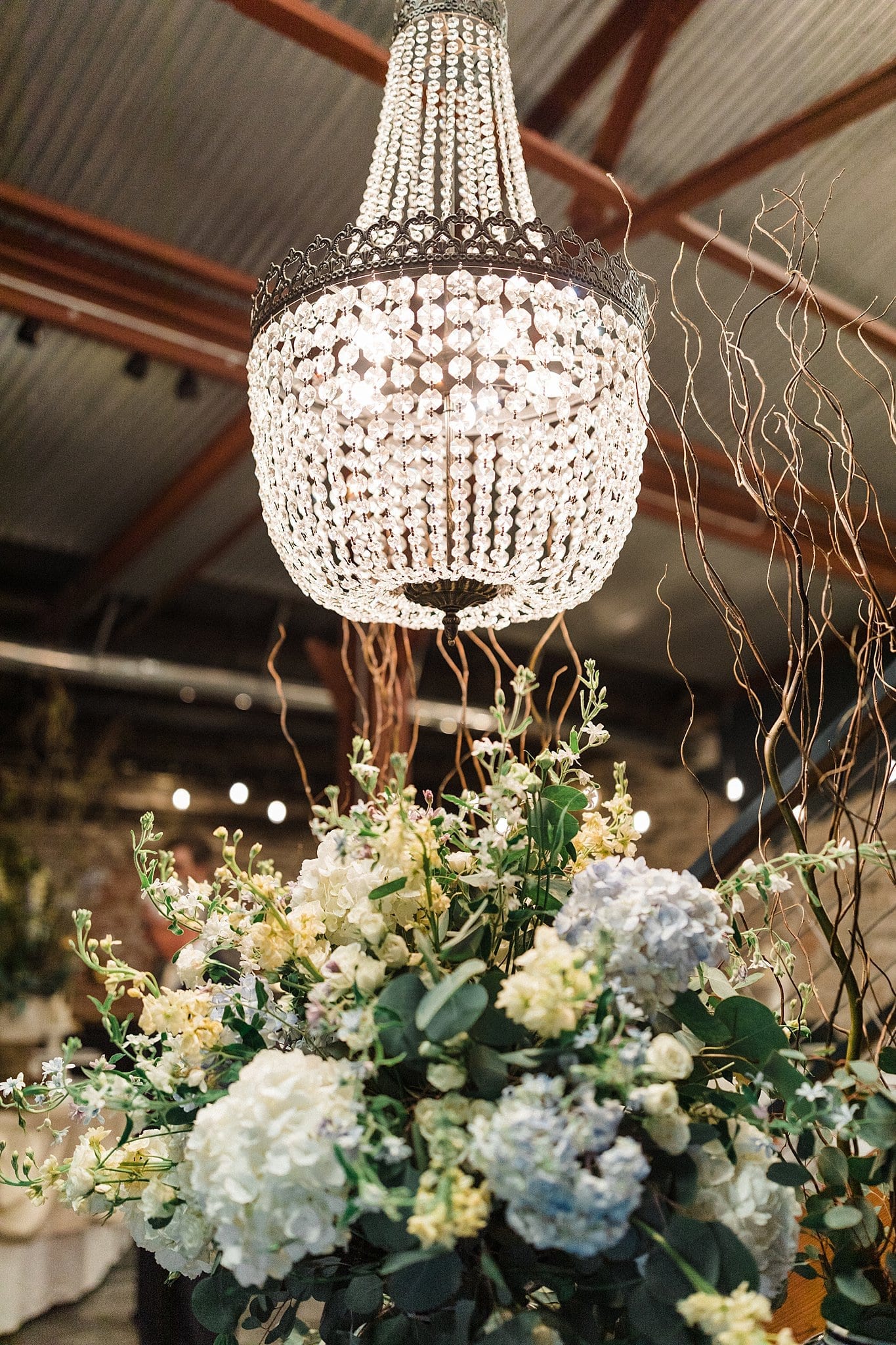 Large bouquet at sign in table underneath crystal chandelier