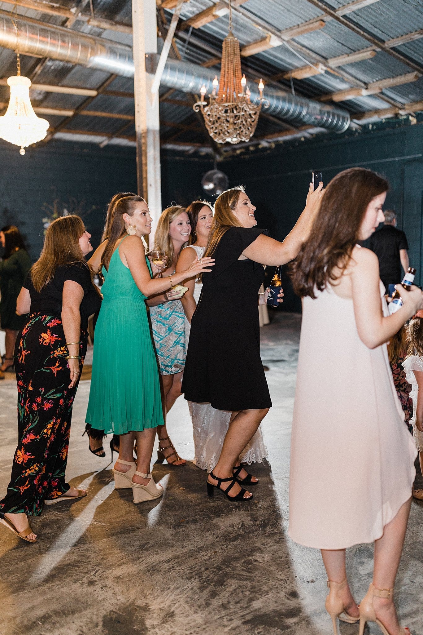 wedding guests take selfie on dance floor at reception