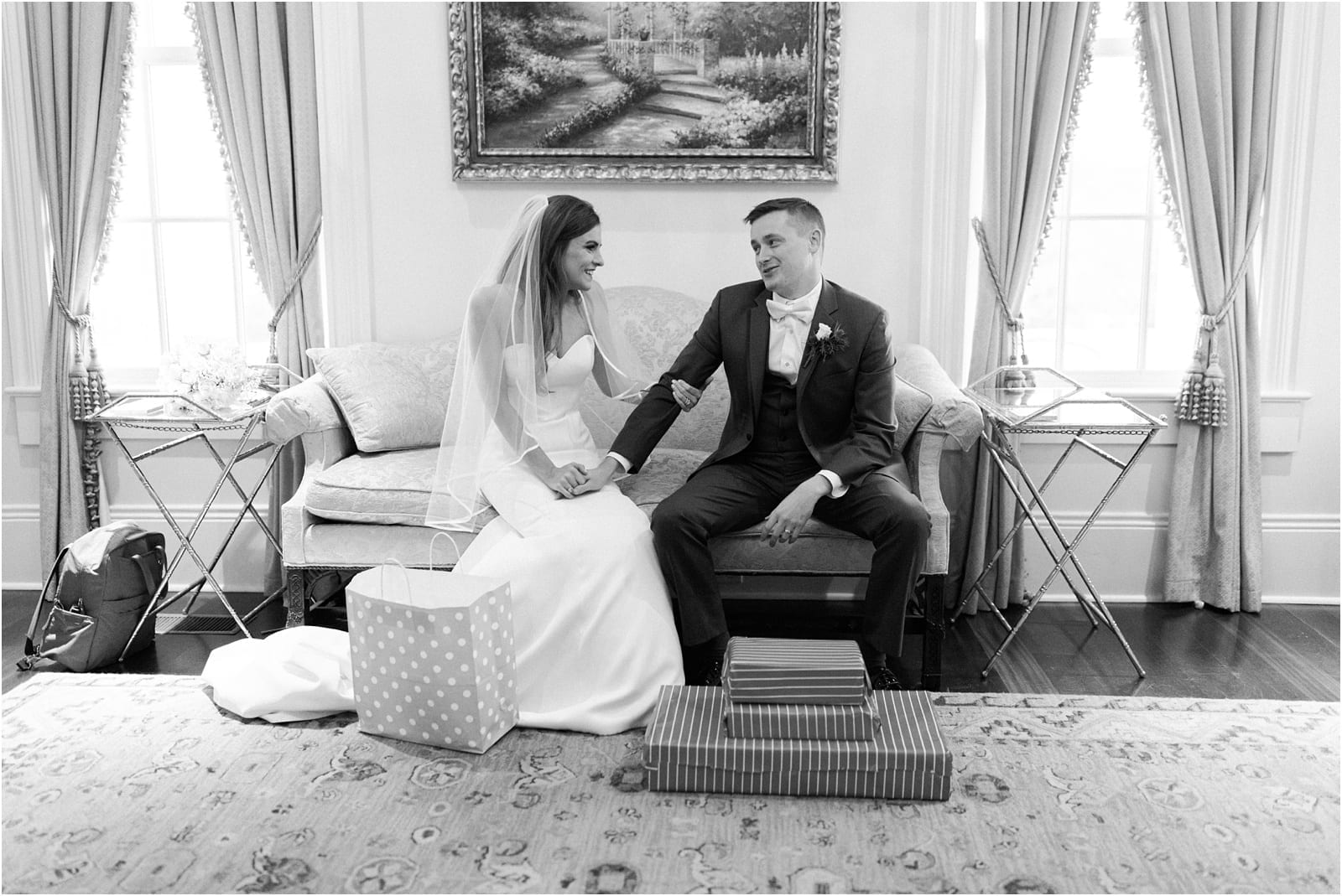 black and white image of bride and groom, exchanging wedding gifts