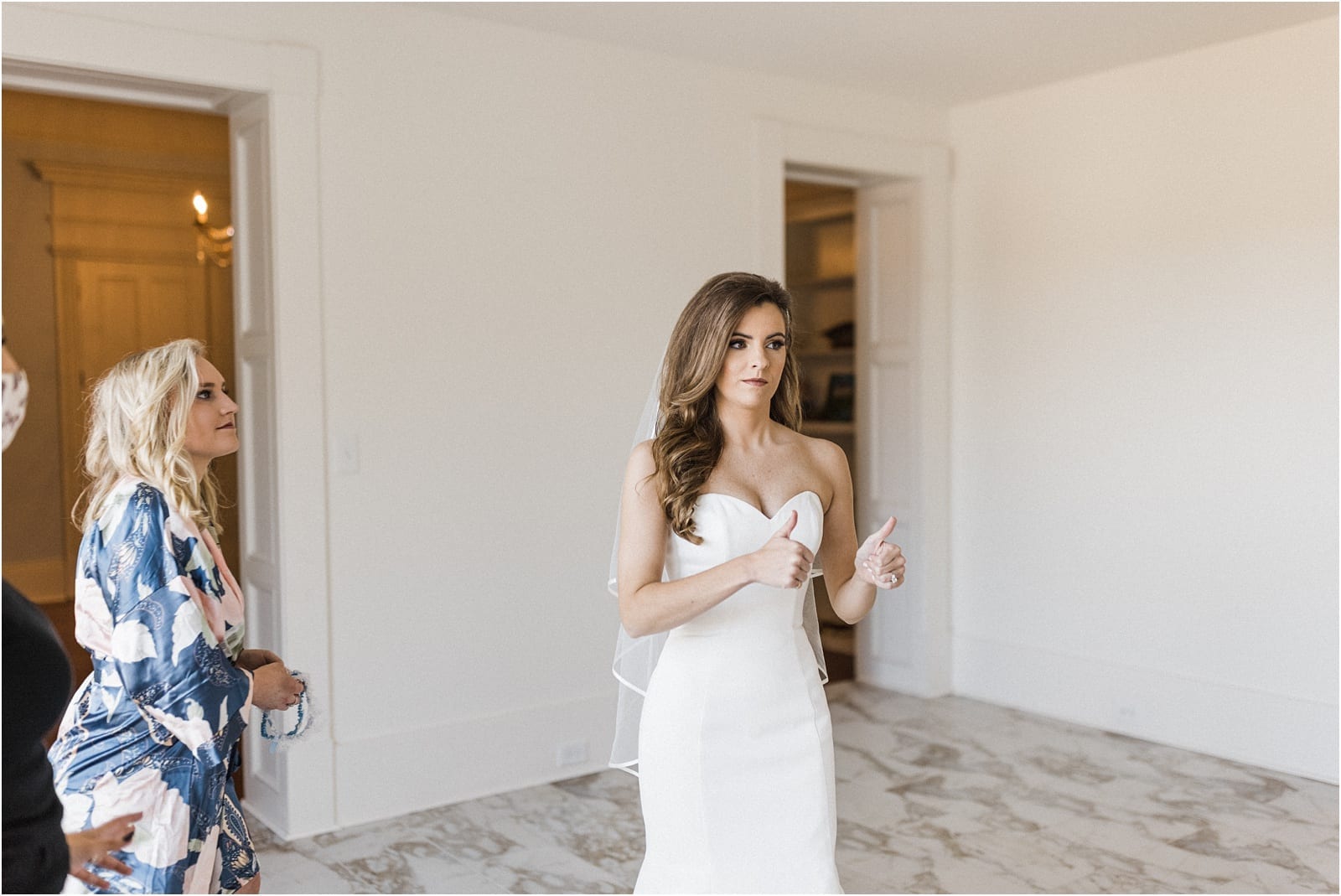 bride gives thumbs up on final touches