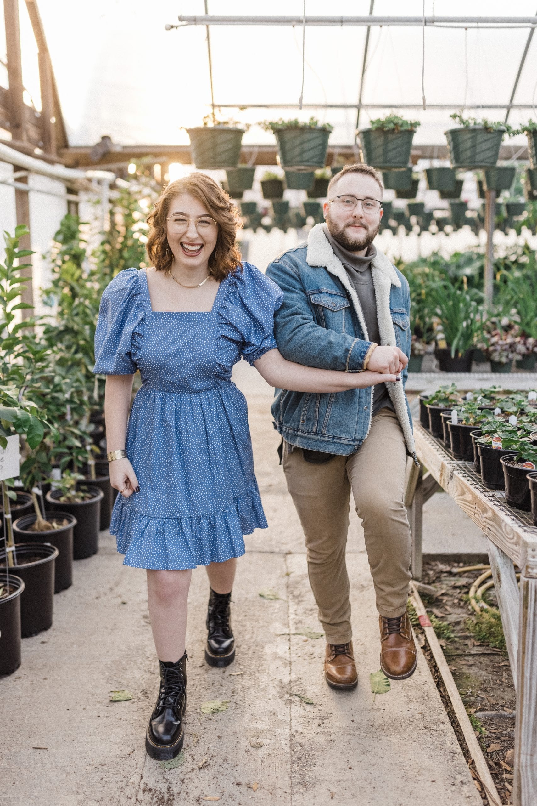 engaged couple laughing in greenhouse