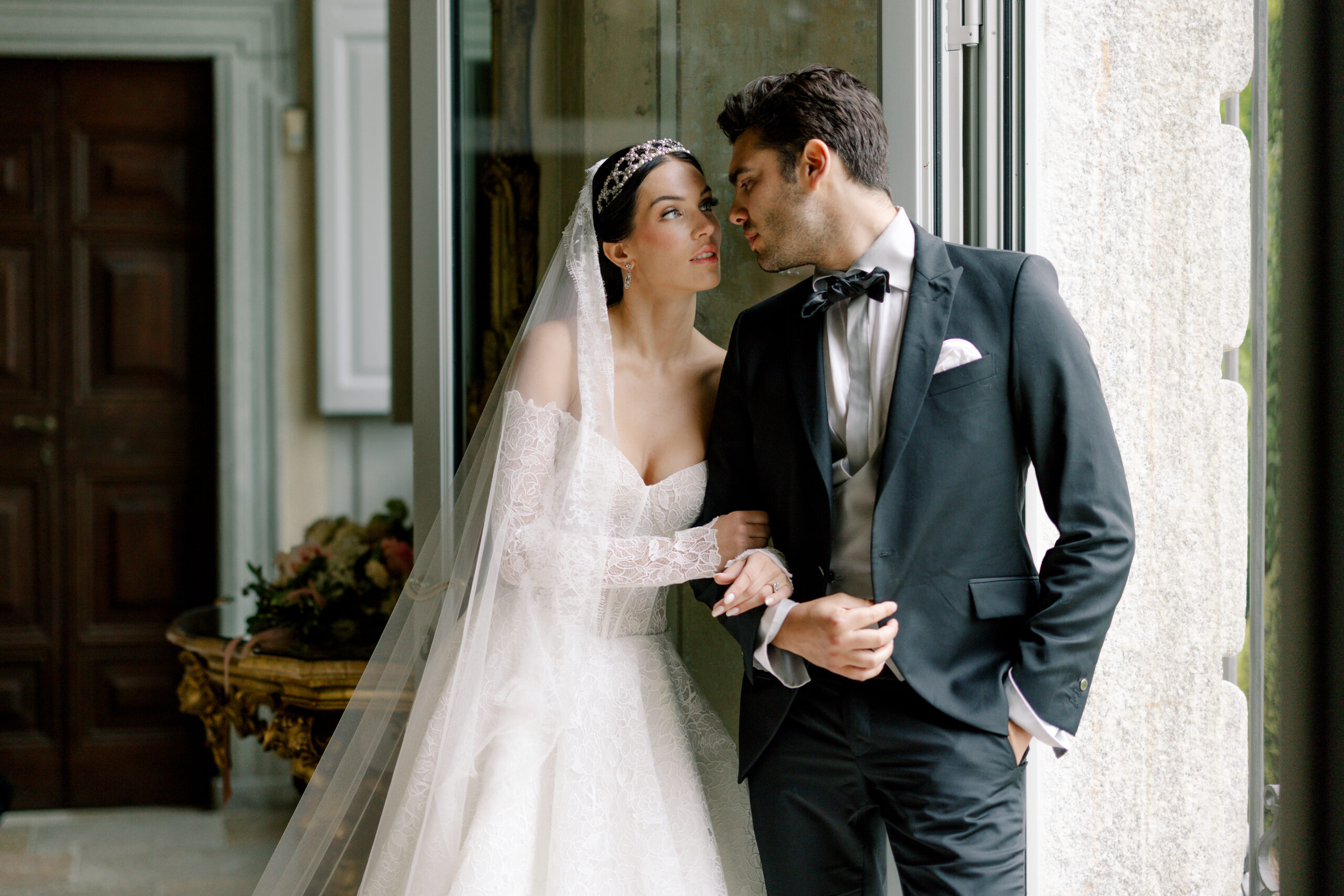 Couple poses close in Italian chateau at destination wedding.